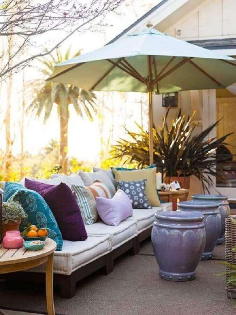 33. Varanda decorada com almofadas coloridas e trio de garden seat lilás – Foto: Revista Micasa