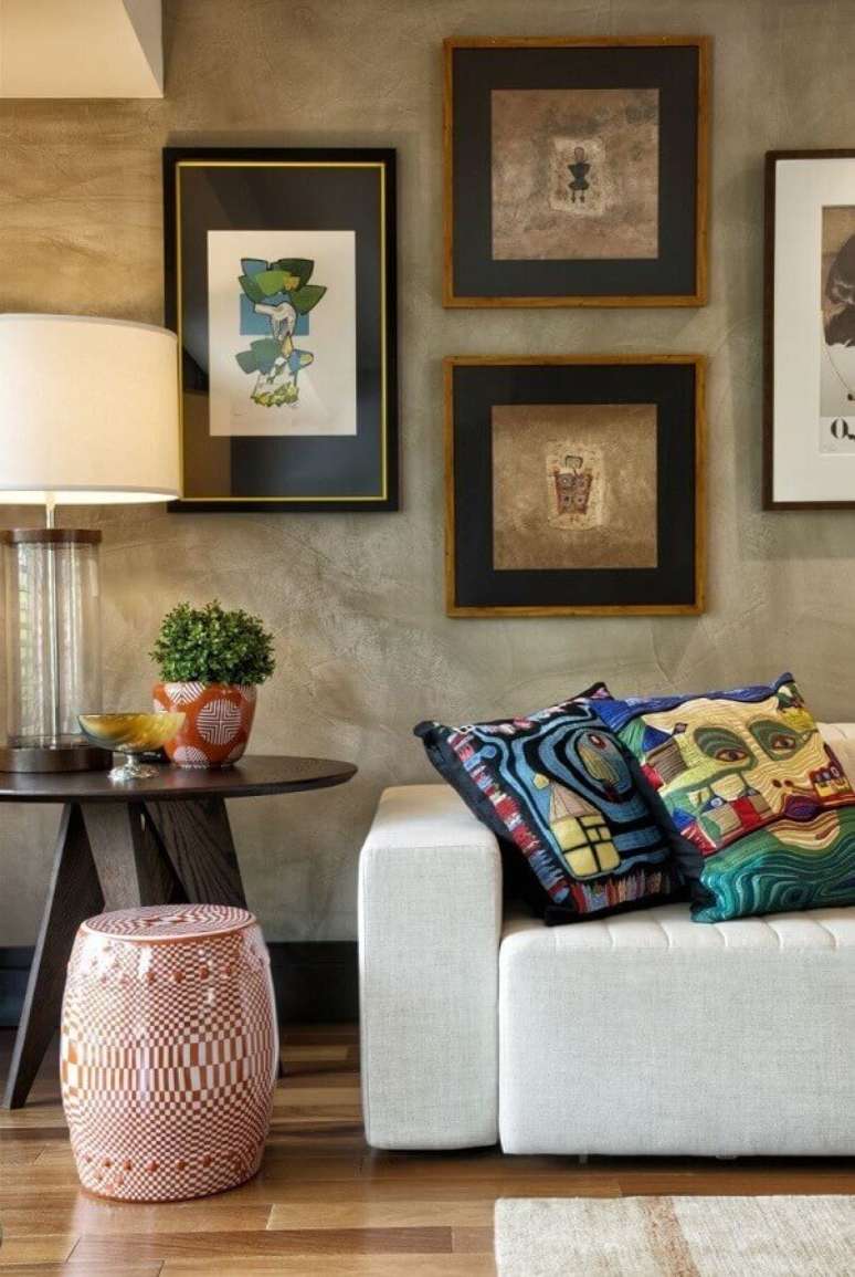 46. Sala decorada com parede de cimento queimado, quadros e garden seat de cer&acirc;mica estampado &ndash; Foto: Decora Fast