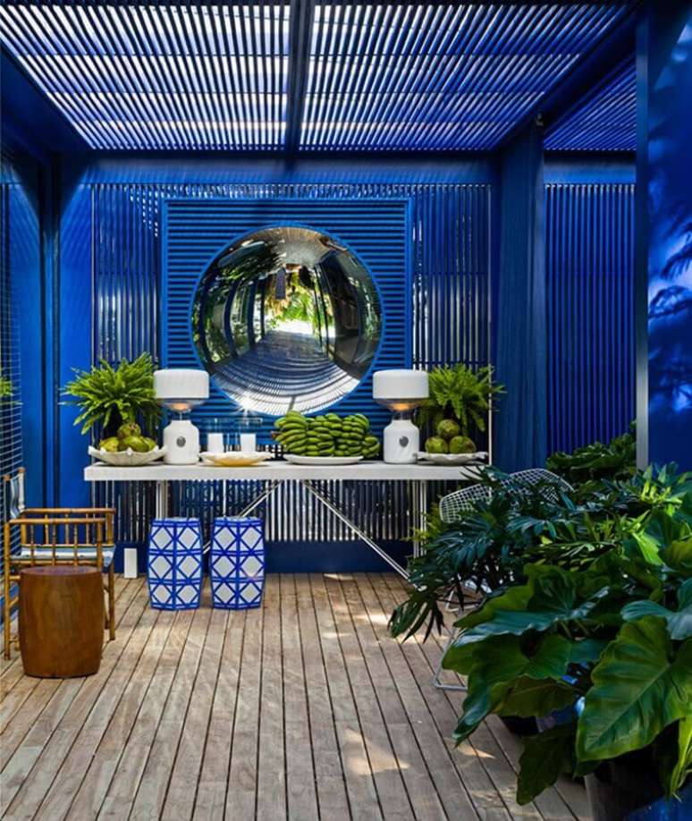 51. Varanda azul decorada com dupla de seat garden e aparador branco &ndash; Foto: Casa de Valentina