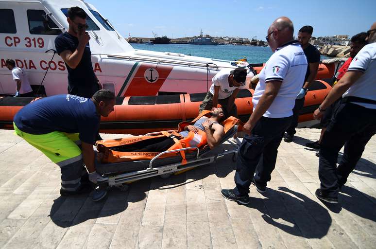 Imigrante que pulou de navio Open Arms é transportado em uma maca em Lampedusa, Itália 20/8/2019 REUTERS/Guglielmo Mangiapane
