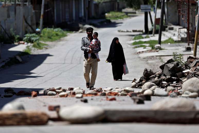 Família da Cashemira passa por bloqueio feito por moradores locais para impedir que forças de segurança da Índia entrem na região. Srinagar, 20/8/2019. REUTERS/Adnan Abidi 