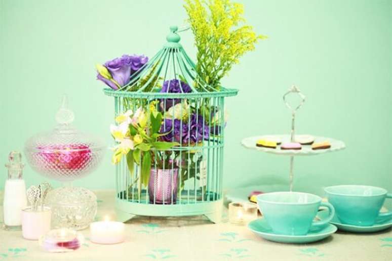 7. Gaiola decorativa com flores enfeita o centra de mesa da casa. Fonte: Pinterest