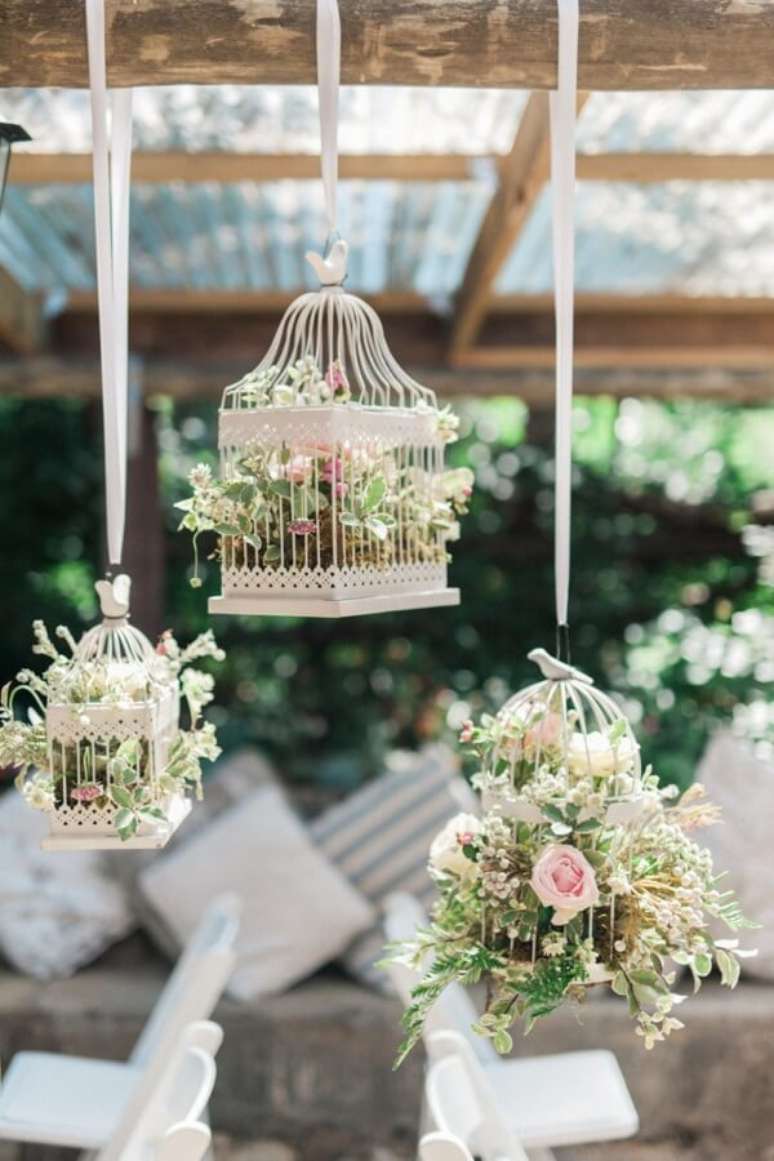 52. Gaiolas decorativas suspensas com flores complementam a decoração da festa de casamento. Fonte: The Wedding blog