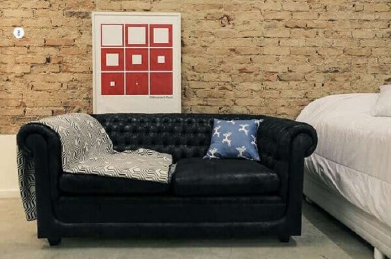 26. Tecido para sofá de couro preto e parede de tijolinho. Fonte: Casa Aberta