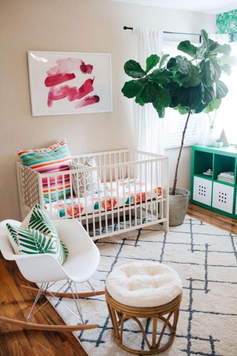 24. Decoração simples com quadros decorativos para quarto de bebê com vaso grande e cadeira de balanço – Foto: Pinterest