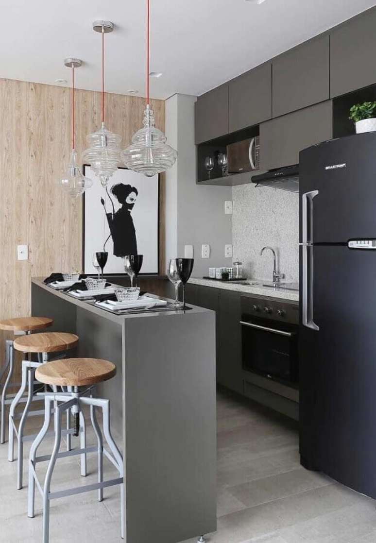 35. Quadros decorativos para cozinha americana pequena com armário cinza e geladeira preta – Foto: Pinterest