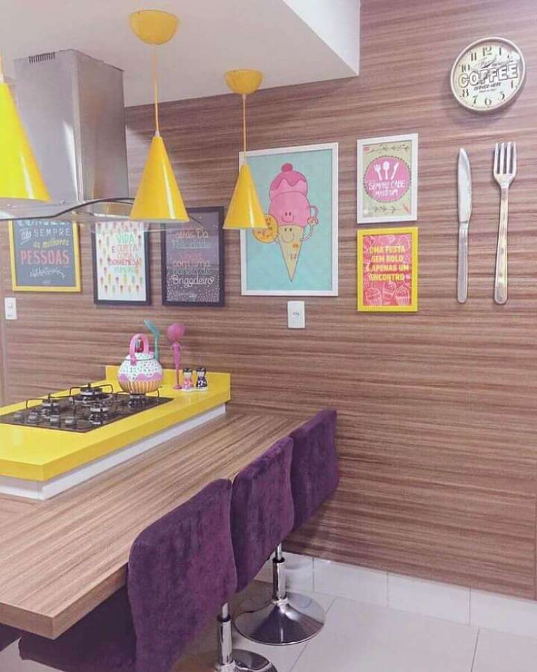36. Decora&ccedil;&atilde;o colorida com quadros decorativos para cozinha com revestimento de madeira e pendentes amarelos &ndash; Foto: Decora&ccedil;&atilde;o de Casa