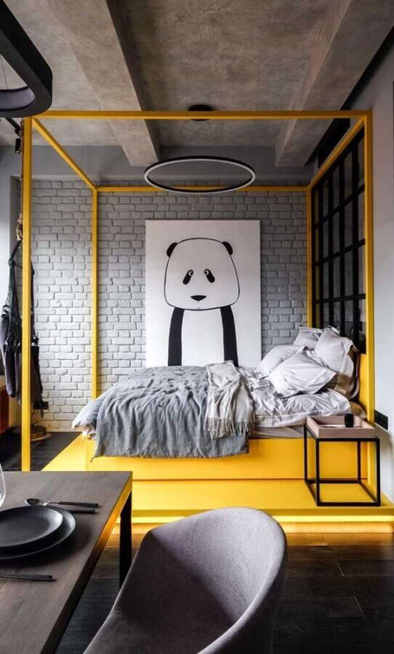41. Quadros decorativos para quarto moderno cinza e amarelo com cimento queimado e parede de tijolinho – Foto: Pinosy