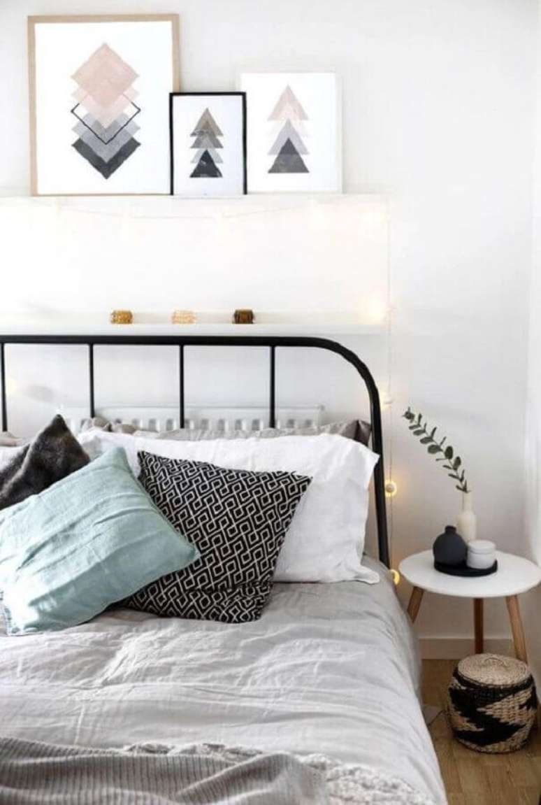 54. Decoração com quadros apoiados em prateleira estreita para quarto com cama de ferro preto – Foto: House Design
