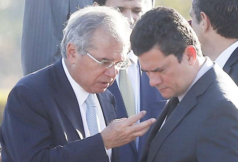 Os ministros da Economia, Paulo Guedes, e da Justiça e Segurança Pública, Sergio Moro, conversam durante cerimônia de hasteamento da bandeira nacional em frente ao Palácio da Alvorada