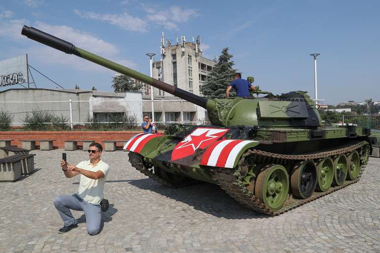 F&atilde; do Estrela Vermelha tira foto na frente de um tanque de guerra sovi&eacute;tico diante do est&aacute;dio Rajko Mitic, onde aconteceu a partida que classificou o time para a fase de grupo da Liga dos Campe&otilde;es. 27/8/2019. REUTERS/Marko Djurica 