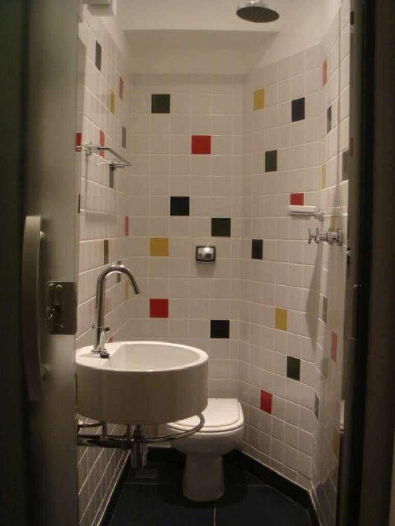 56. Banheiro coberto com azulejos brancos e coloridos. Projeto de Andre Martins