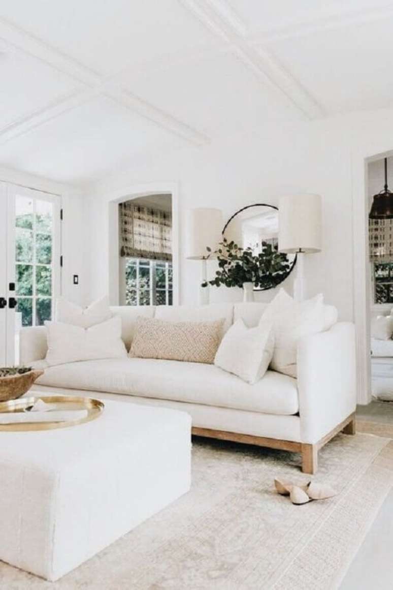 16. Decoração clean para sala com sofá branco e espelho redondo – Foto: American Home