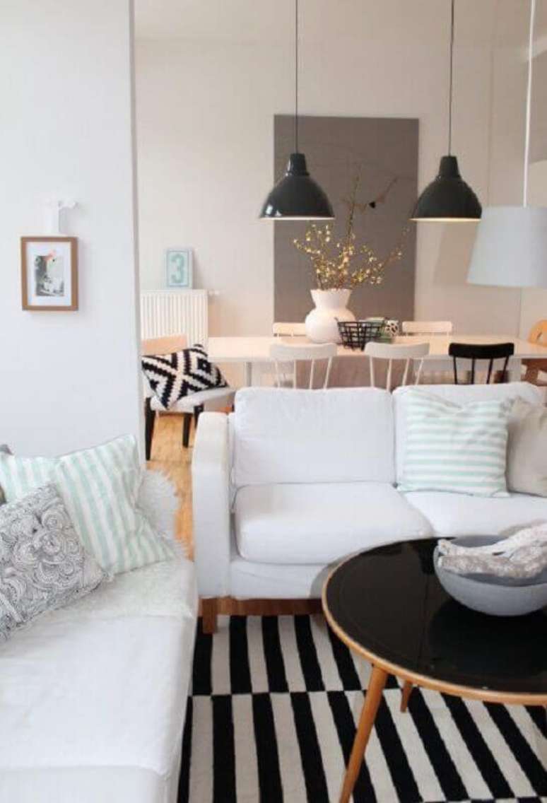 24. Invista no sofá branco com base de madeira para um toque aconchegante na decoração – Foto: Côté Maison