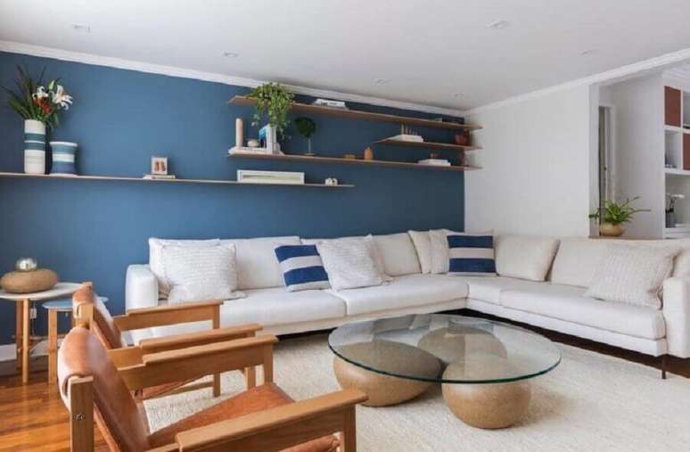 5. Decoração com poltronas de madeira e sofá de canto branco para sala ampla com paredes azuis – Foto: Voa Arquitetura