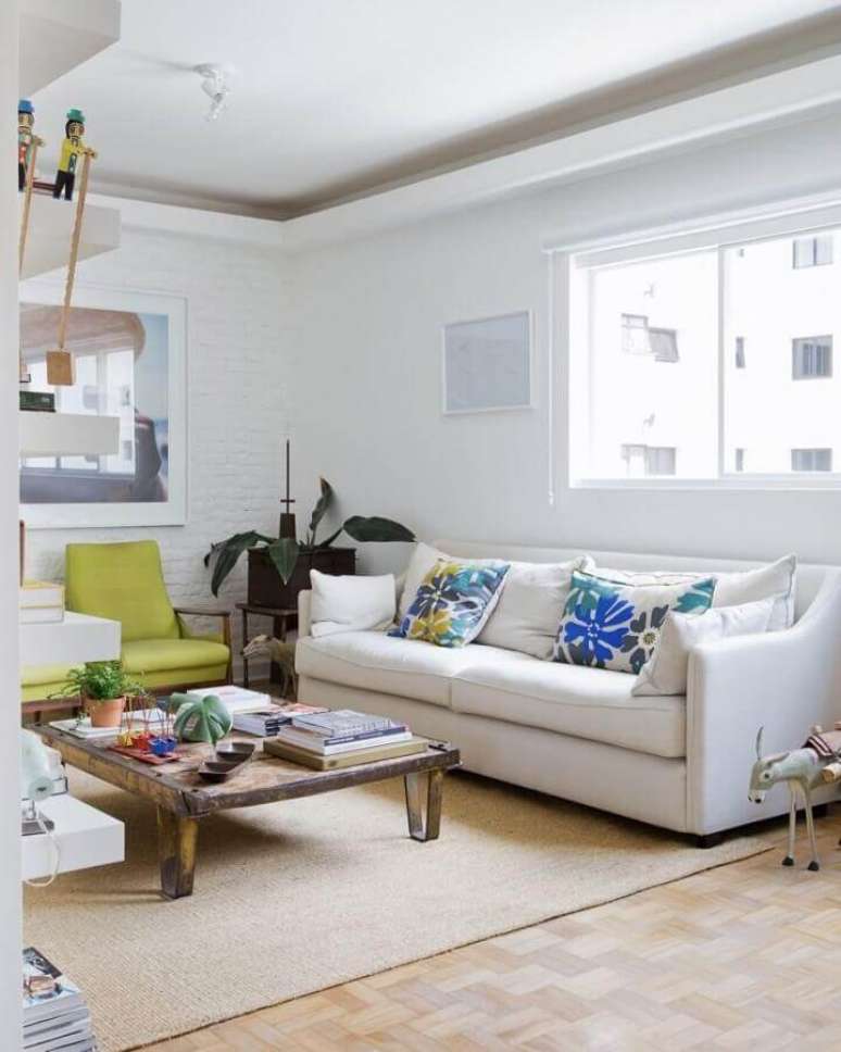 28. Invista em detalhes coloridos na sala de estar decorada com sofá branco de couro – Foto: Reedecore