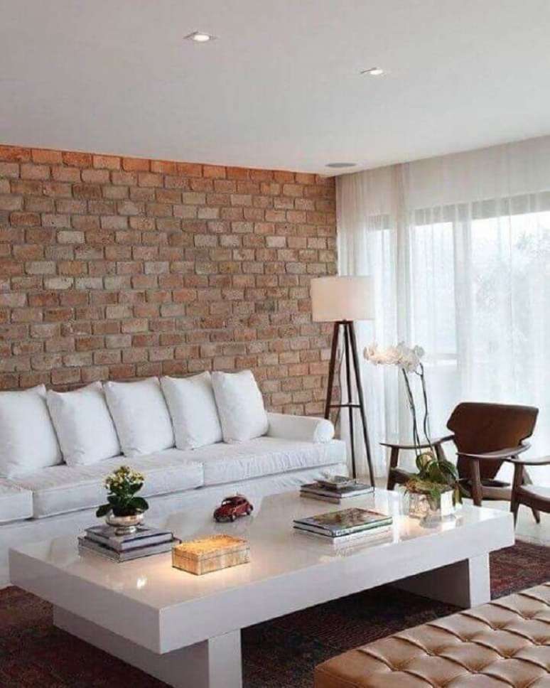 33. Sala de estar decorada com parede de tijolinho e sofá branco – Foto: Ideias Decor