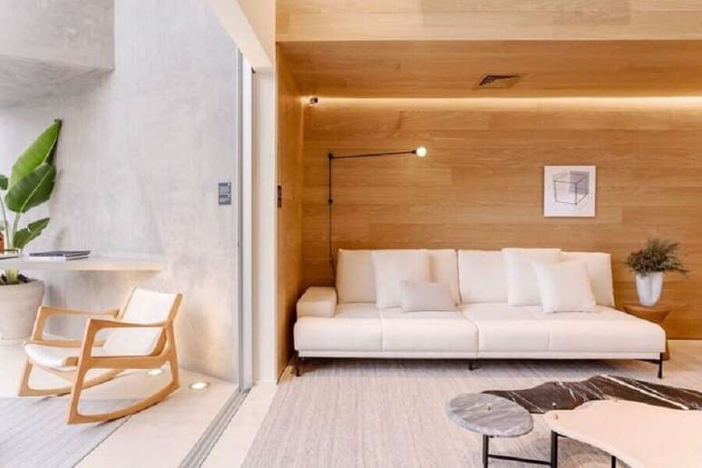 41. Sala integrada com varanda decorada com revestimento de madeira e sofá branco moderno – Foto: Suite Arquitetos