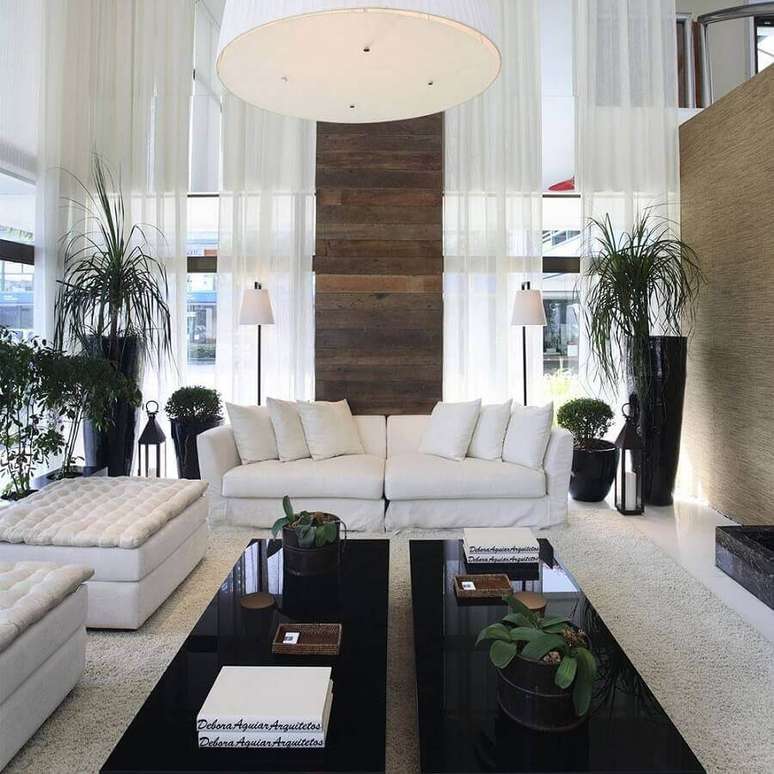46. Sala sofisticada decorada com sofá branco e mesas de centro pretas – Foto: Assetproject