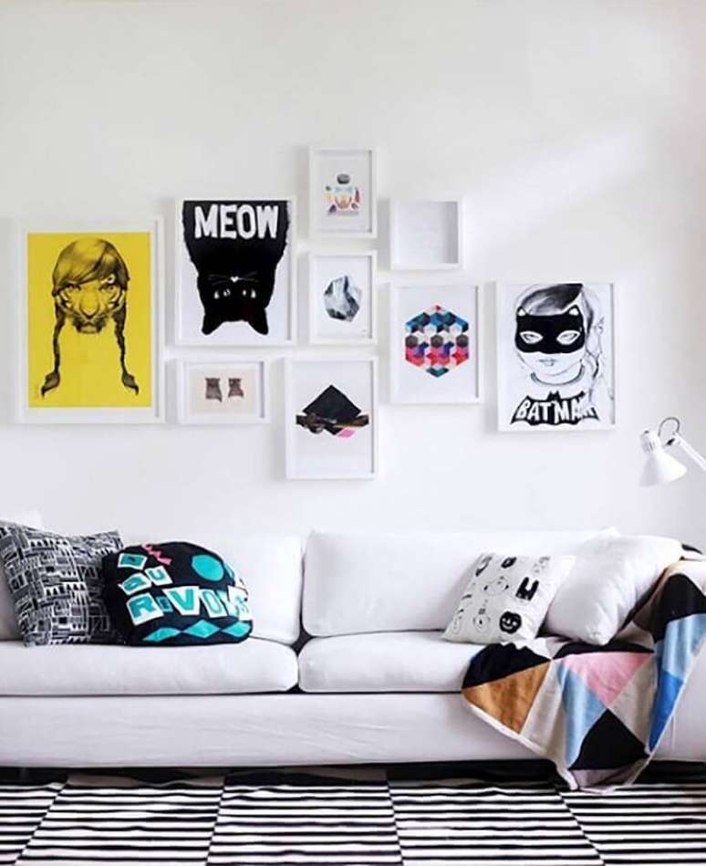 50. Sala decorada com sofá branco, quadrinhos decorativos e almofadas divertidas – Foto: Assetproject