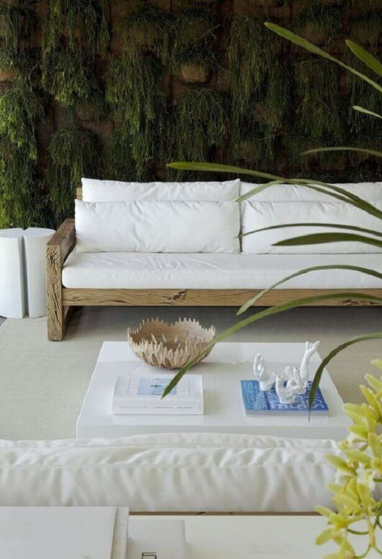 63. Varanda decorada com jardim vertical e sofá branco com base de madeira – Foto: Diego Revolto Arquitetura