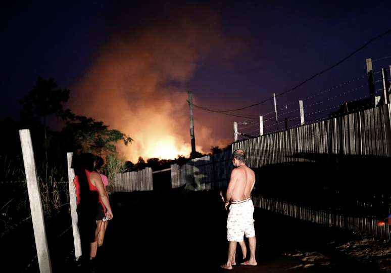 Família observa incêndio na floresta amazônica na cidade de Altamira, no Pará
27/08/2019 REUTERS/Nacho Doce