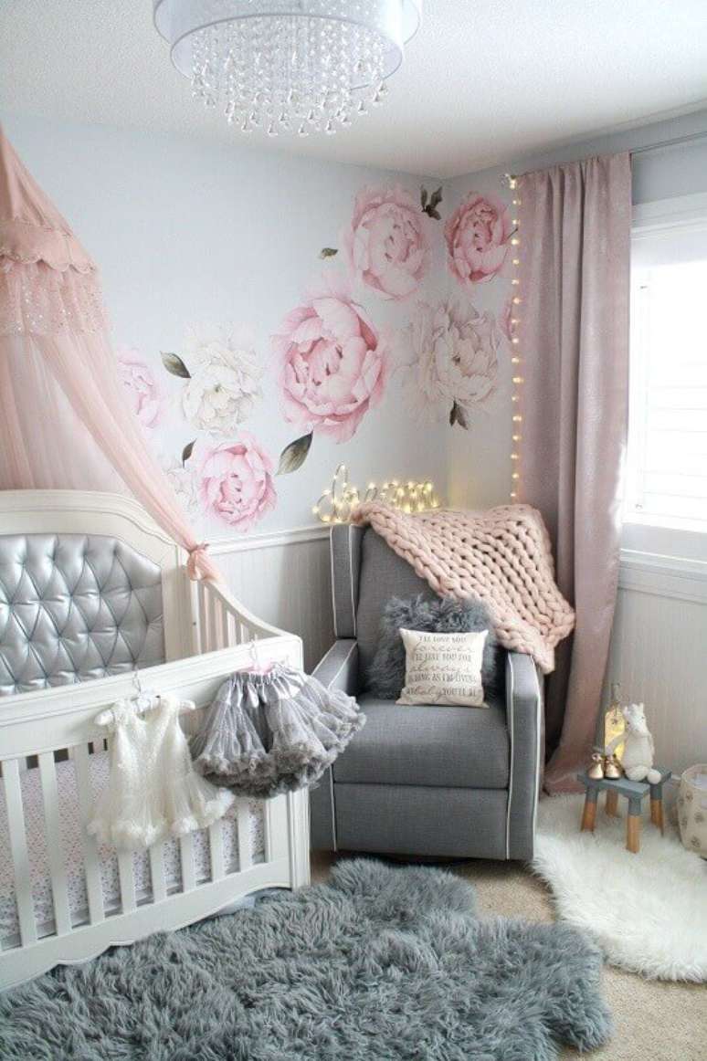 16. Quarto de bebê feminino decorado com adesivo de parede floral e tapete felpudo cinza e branco – Foto: Pinterest