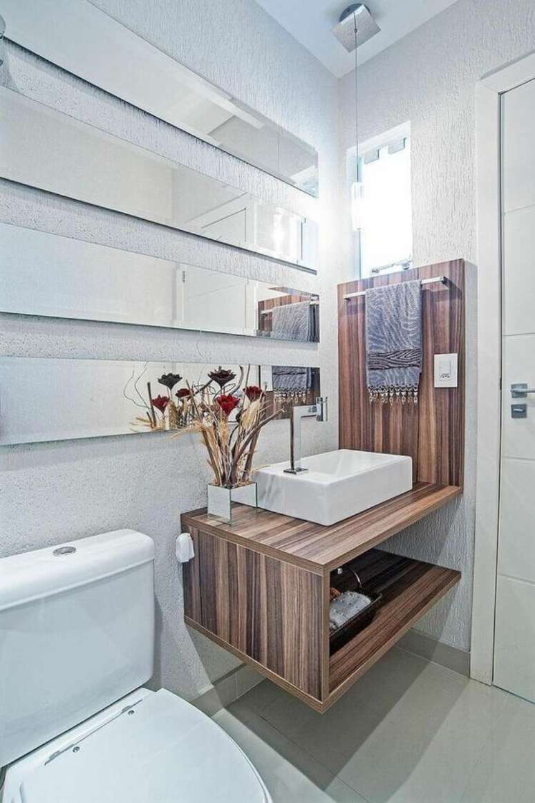 43. A toalha de lavabo escura contrasta bem com a madeira do gabinete. Projeto de Patrícia Azoni