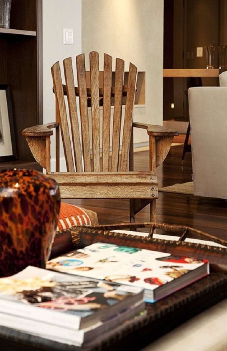 39. Sala de estar com cadeira de madeira e mesa de centro. Projeto por Fernando Piva