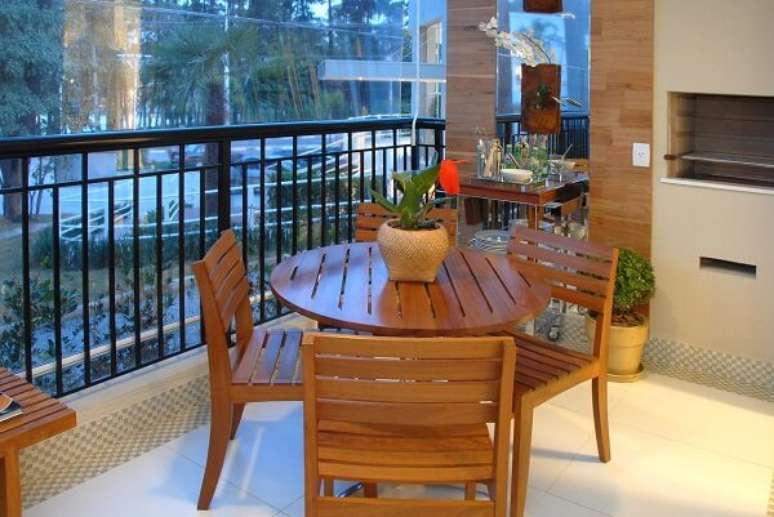 54. Varanda gourmet com mesa redonda e modelo de cadeira de madeira. Projeto por Marel Grupo Factory