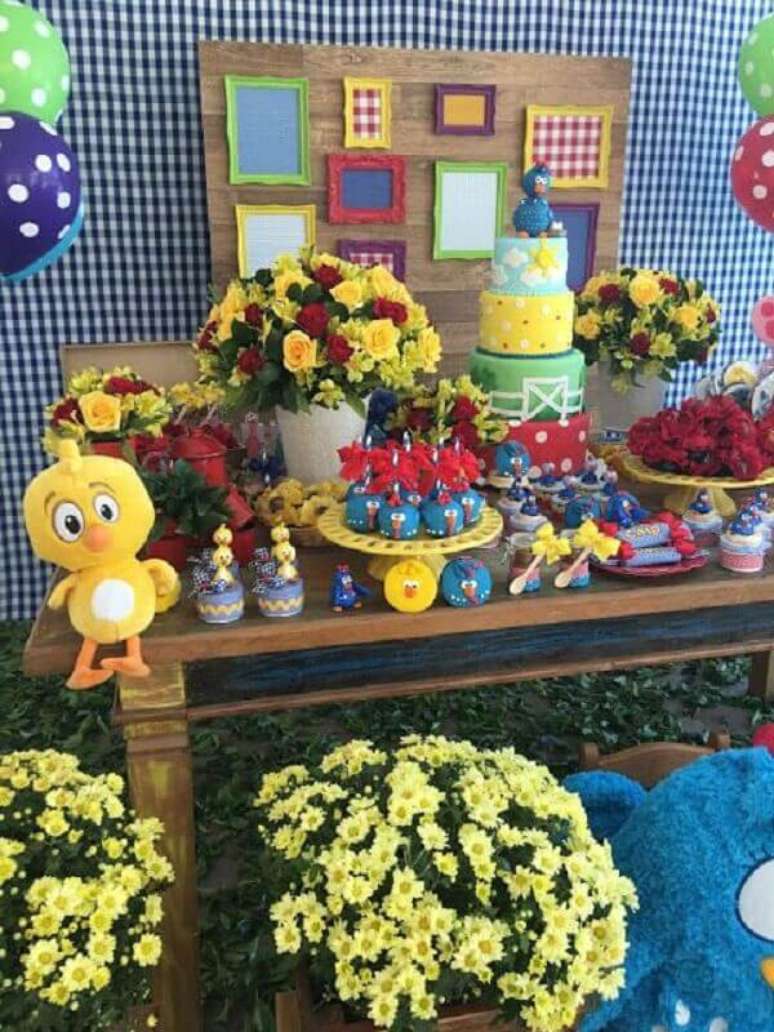 24. Arranjo de flores e painel xadrez para decoração de festa de aniversário da Galinha Pintadinha – Foto: Encontrando Ideias