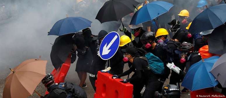 Manifestantes usaram guarda-chuvas, capacetes e placas de trânsito para se proteger