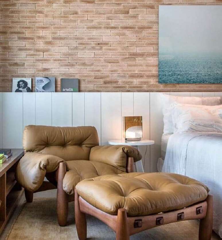 17. Poltrona com puff para quarto com papel de parede de tijolinho &ndash; Foto: Paola Ribeiro