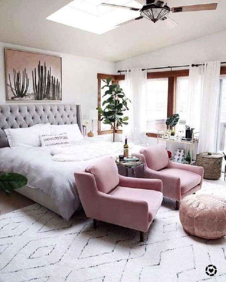 21. Poltrona para quarto de casal amplo decorado com vaso de planta e cabeceira capitonê – Foto: Article