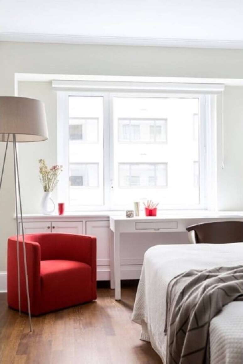 3. O tom vermelho da poltrona para quarto de casal ganhou bastante destaque na decoração clean – Foto: Patricia Martinez