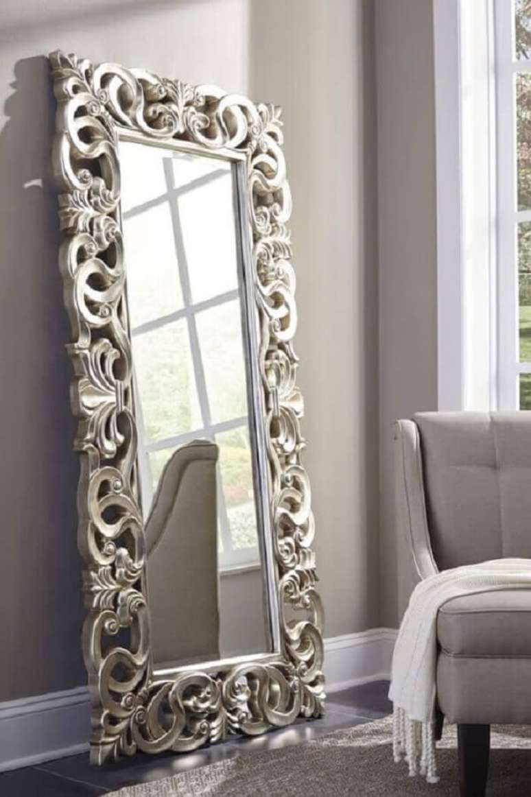 28. Moldura para espelho grande provençal encanta a de coração da sala de estar. Fonte: The Classy Home