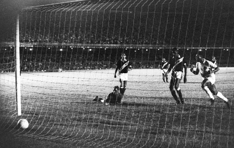 Pelé (direita) marca seu milésimo gol cobrando pênalti na partida entre Vasco da Gama e Santos, realizada no Maracanã. Andrada (deitado à esquerda) fica indignado por não conseguir pegar a cobrança (19/11/1969)