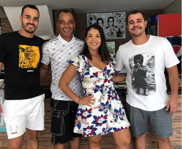 Danilo (de branco, à direita) em foto com o pai Cafu e a família