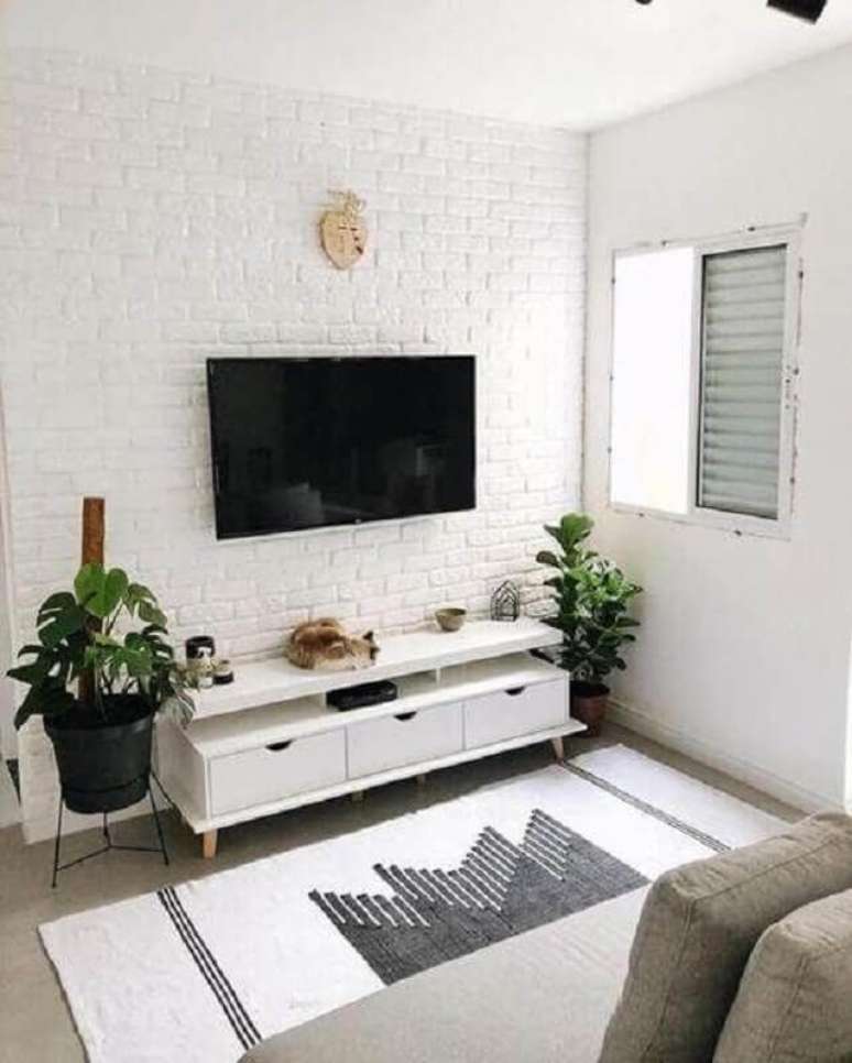 16. Rack para sala pequena simples decorada com parede de tijolinho branco – Foto: Decoração de Casa