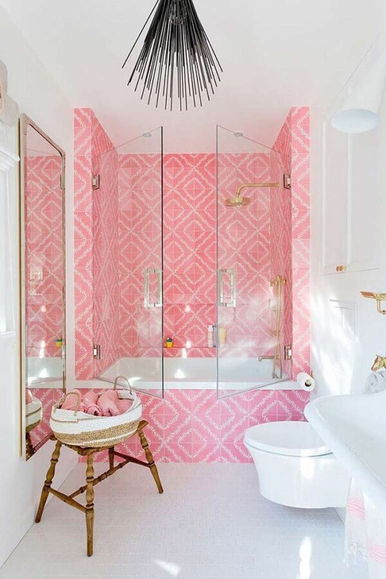 36. Banheiro feminino todo branco decorado com revestimento rosa na área do box com banheira – Foto: CoachDecor