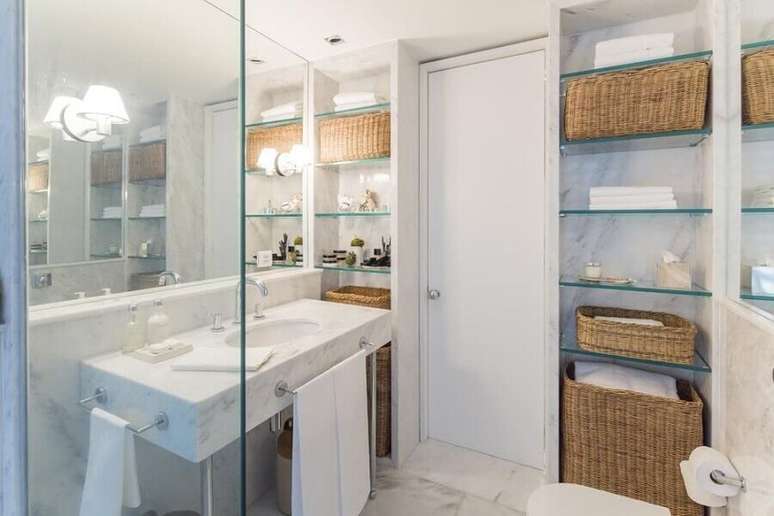42. Banheiro feminino todo branco decorado com prateleiras de vidro e cestos organizadores &ndash; Foto: Fabr&iacute;cio Cardoso