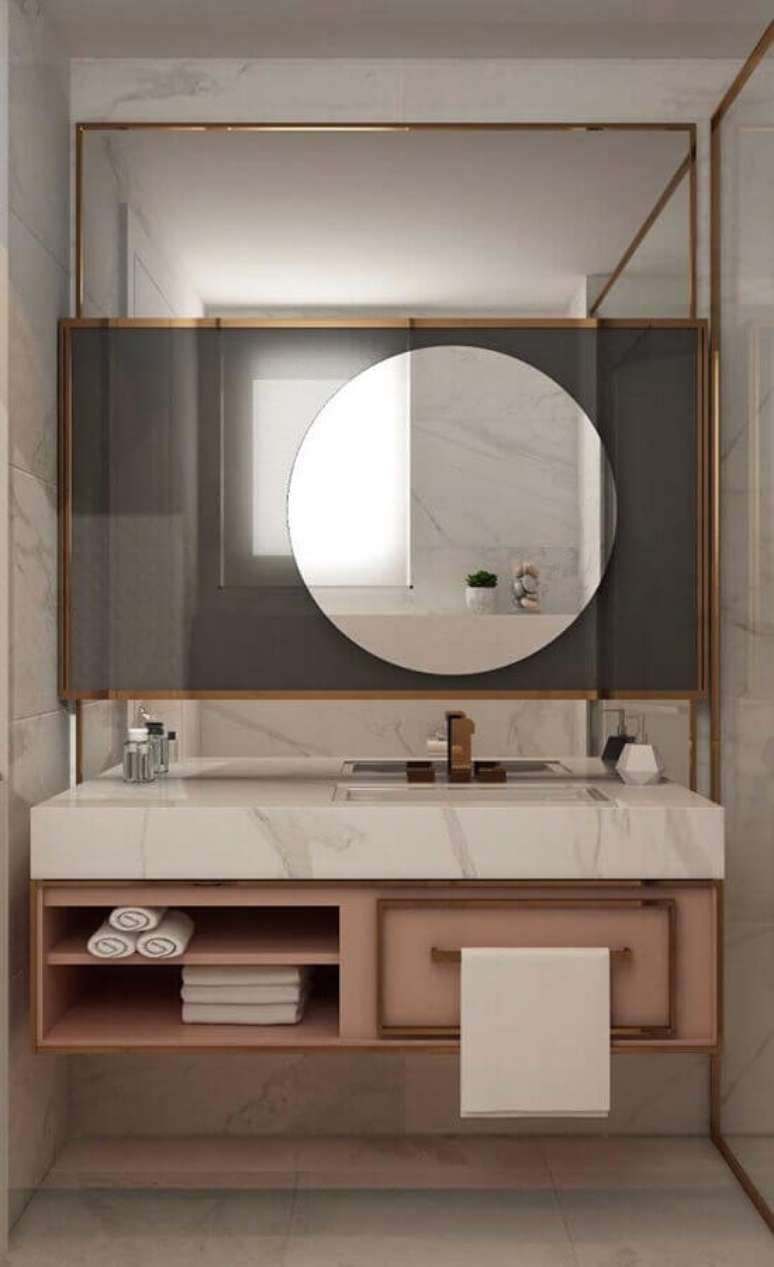 45. Decoração moderna para banheiro feminino com armário rosa e espelho redondo – Foto: Pinosy