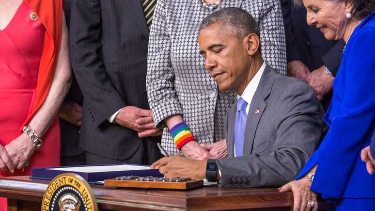 Presidente Barack Obama assinando um projeto de lei com a mão esquerda