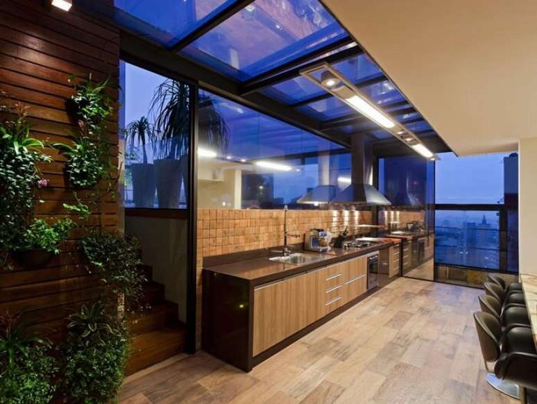 25. Cozinha ampla com coifa met&aacute;lica e torneira gourmet de mesa. Projeto por Mariana Borges e Thaysa Godoy