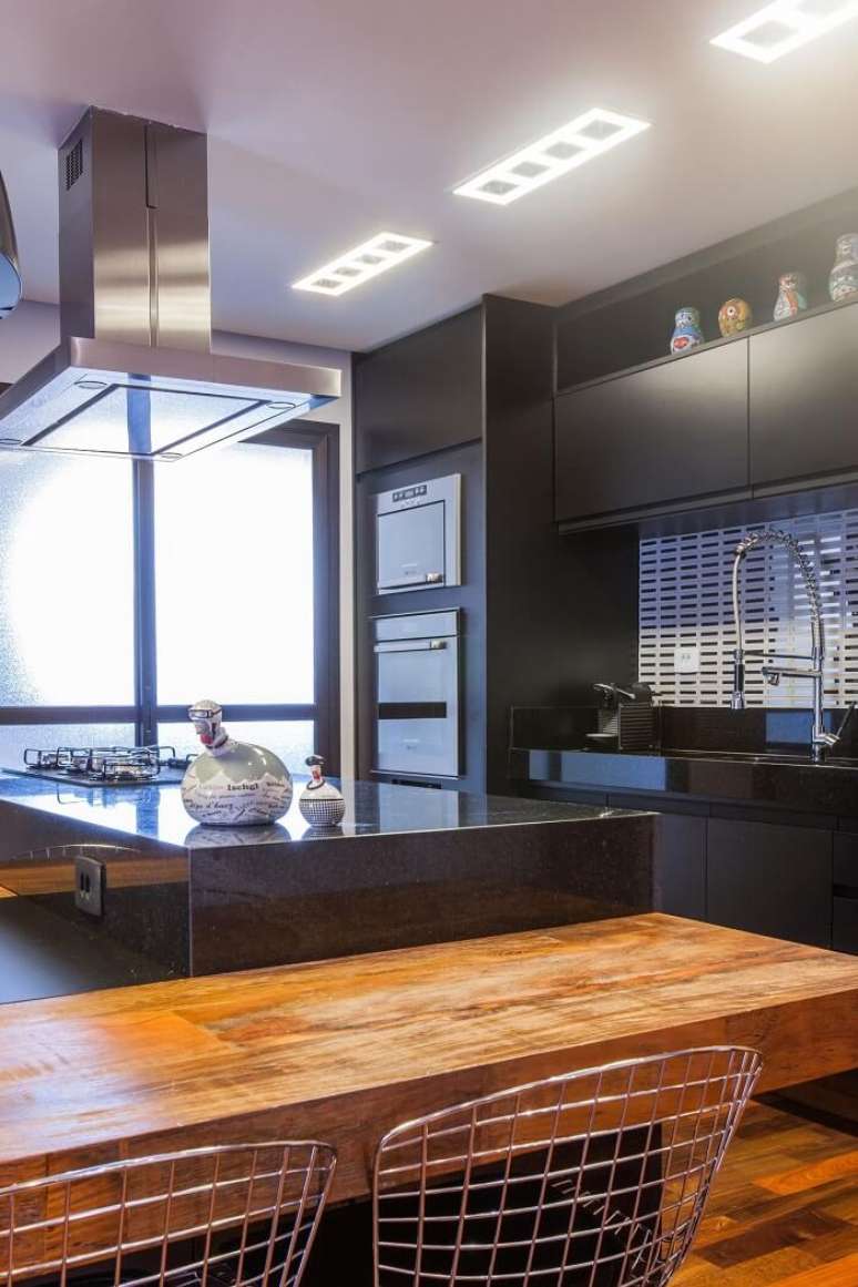 33. Cozinha com decora&ccedil;&atilde;o escura e torneira gourmet. Projeto por Liane Martins