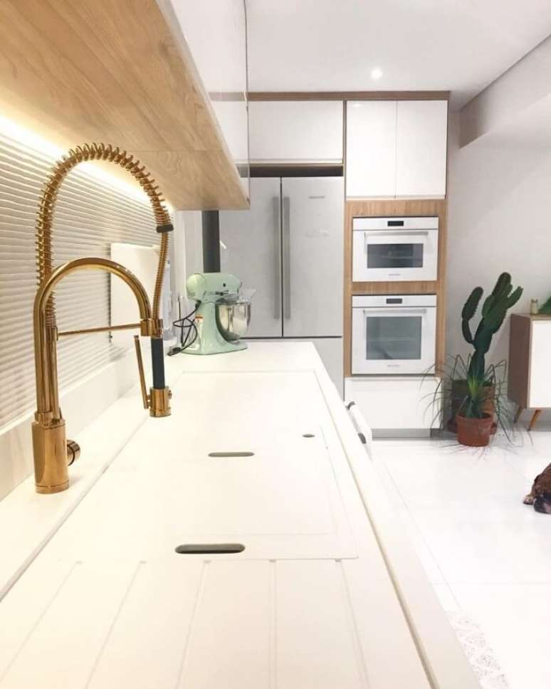 55. Bancada branca com torneira gourmet dourada. Fonte: Pinterest