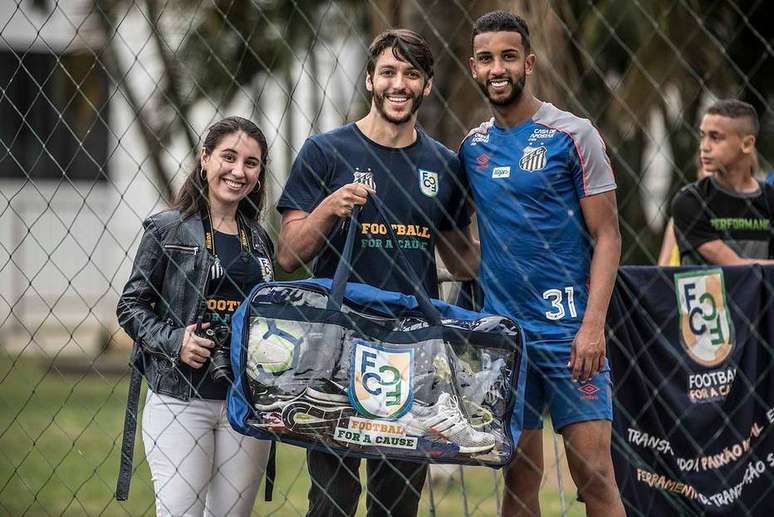 Manuella Carvalho e André Georges, da Football for a cause, e o lateral Jorge, do Santos: doação de materiais para projetos sociais