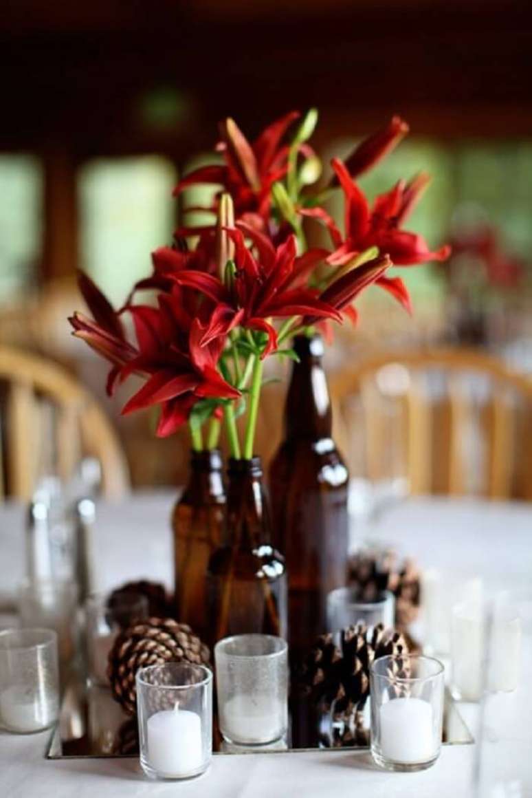 33. Decora&ccedil;&atilde;o do centro de mesa para festa Ch&aacute; Bar feita com garrafas de vidro e flores. Fonte: Pinterest