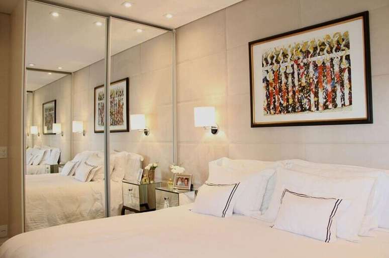 27. Quarto decorado em cores neutras com parede estofada e guarda roupa casal com espelho &ndash; Foto: Carolina Molinari Thales Drummond