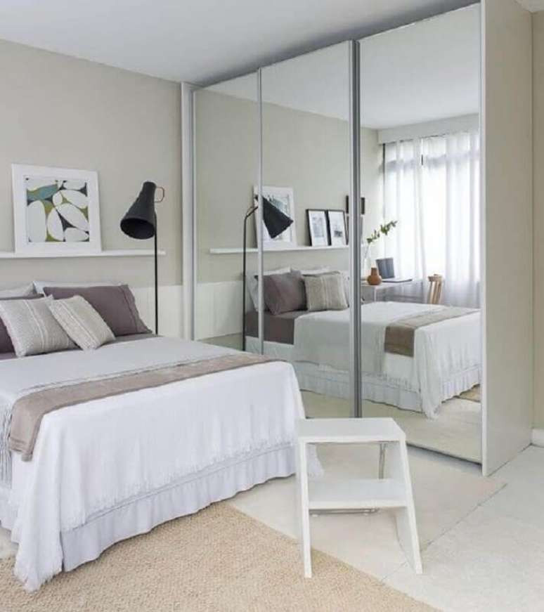 28. Decora&ccedil;&atilde;o clean com guarda roupa com espelho para quarto de casal todo branco com lumin&aacute;ria de piso &ndash; Foto: Decora&ccedil;&atilde;o Simples